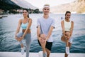 Group of happy people exercising outdoor. Sport, fitness, friendship and healthy lifestyle concept