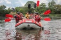 Group of happy people with guide whitewater rafting and rowing on river, extreme and fun sport Royalty Free Stock Photo