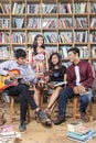 Group of happy people playing music and sing song in library room