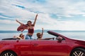 Group of happy people in red convertible car. Royalty Free Stock Photo