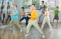 Group of happy preteen children with female teacher practicing hip hop in dance studio Royalty Free Stock Photo