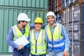 Group of happy professional engineers and foreman container cargo wearing yellow hardhat and safety vests checking stock into