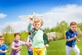 Group of happy running children with airplane toy