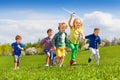 Group of happy running kids with white airplane