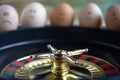 Group of happy and sad eggs friends  make bets gambiling at the toy roulette in the toy casino. Roulette in focus Royalty Free Stock Photo