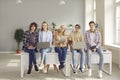 Group of happy school, college or university students sitting on desk with digital devices Royalty Free Stock Photo