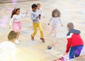 Group of happy schoolchildren playing football together