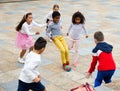 Group of happy schoolchildren playing football together