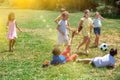 Group of happy schoolchildren playing football together