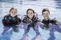 A group of happy scuba divers standing in a pool