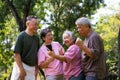 Group of happy Senior Retirement Using Smartphone and laughing outdoors at the park after a workout and spending time together, Royalty Free Stock Photo