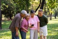 Group of happy Senior Retirement Using Smartphone and laughing outdoors at the park after a workout and spending time together, Royalty Free Stock Photo