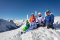 Group of happy ski school kids sit on mountain top Royalty Free Stock Photo