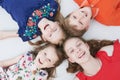 Group of smiling four kids laying on floor. Upper view