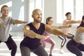 Group of happy, smiling young people doing squats during a fitness workout at the gym Royalty Free Stock Photo