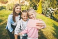 Group of happy teenage girls laughing and taking a selfie on a mobile phone outdoors. Royalty Free Stock Photo