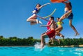 Teenage children jump and throw toys in the pool Royalty Free Stock Photo