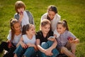 Group of happy teenagers laughing outdoors. children spend time with gadgets outdoors Royalty Free Stock Photo