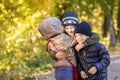 Group of happy three kids having fun outdoors in autumn park. Cute children enjoy hugging together against golden fall background. Royalty Free Stock Photo