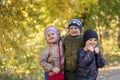 Group of happy three kids having fun outdoors in autumn park. Cute children enjoy hugging together against golden fall background. Royalty Free Stock Photo