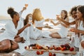 Group of happy women female friends having cozy summer picnic with wine or champagne, having hen party on coastline Royalty Free Stock Photo