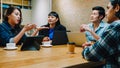 Group of happy young Asia business coworkers using laptop in team casual meeting, startup project discussion at cafe restaurant. Royalty Free Stock Photo