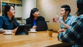 Group of happy young Asia business coworkers using laptop in team casual meeting, startup project discussion at cafe restaurant. Royalty Free Stock Photo