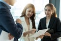 Group of happy young asian corporate people teammates meeting discussing business in office Royalty Free Stock Photo