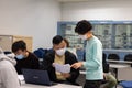 15 11 2021 group of happy young boys and girls with face mask work, discuss, study on assignment and teaching materials together