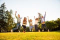 Group of happy young college students jumping at park Royalty Free Stock Photo