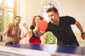 Group of happy young friends playing ping pong table tennis