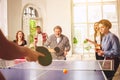 Group of happy young friends playing ping pong table tennis Royalty Free Stock Photo