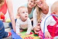 Group of happy young mothers watching their cute and healthy babies Royalty Free Stock Photo