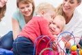 Group of happy young mothers watching their cute and healthy babies play Royalty Free Stock Photo