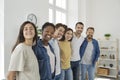 Group of happy young multiethnic men and women standing together, hugging and smiling Royalty Free Stock Photo