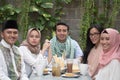 Group of happy young muslim having dinner outdoor looking to cam