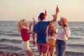 Group of happy young people dancing at the beach on beautiful summer sunset Royalty Free Stock Photo