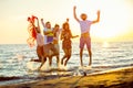 Group of happy young people dancing at the beach on beautiful summer sunset Royalty Free Stock Photo