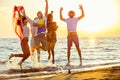 Group of happy young people dancing at the beach on beautiful summer sunset Royalty Free Stock Photo