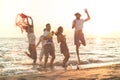 Group of happy young people dancing at the beach on beautiful summer sunset Royalty Free Stock Photo