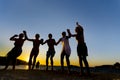 Group of happy young people dancing at the beach at sunset Royalty Free Stock Photo
