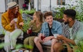 Group of happy young people sitting in outdoors cafe on town trip, talking. Royalty Free Stock Photo