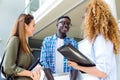 Group of happy young students speaking in a university. Royalty Free Stock Photo