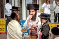 A group of Hasidim pilgrims in traditional clothing emotionally talk. Rosh hashanah holiday, Jewish New Year.