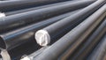 Group of HDPE pipes stack on the ground in construction site for underground water piping installation work Royalty Free Stock Photo