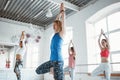 Group of healthy woman training together and doing fit exercise in white gym. People practice yoga poses together indoor Royalty Free Stock Photo