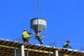 A group of high-rise assemblers work on the top floor of a construction site.