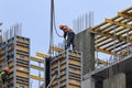 A group of high-rise assemblers work on the top floor of a construction site.