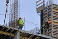 A group of high-rise assemblers work on the top floor of a construction site.