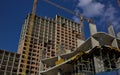 A group of high-rise assemblers work on the top floor of a construction site.